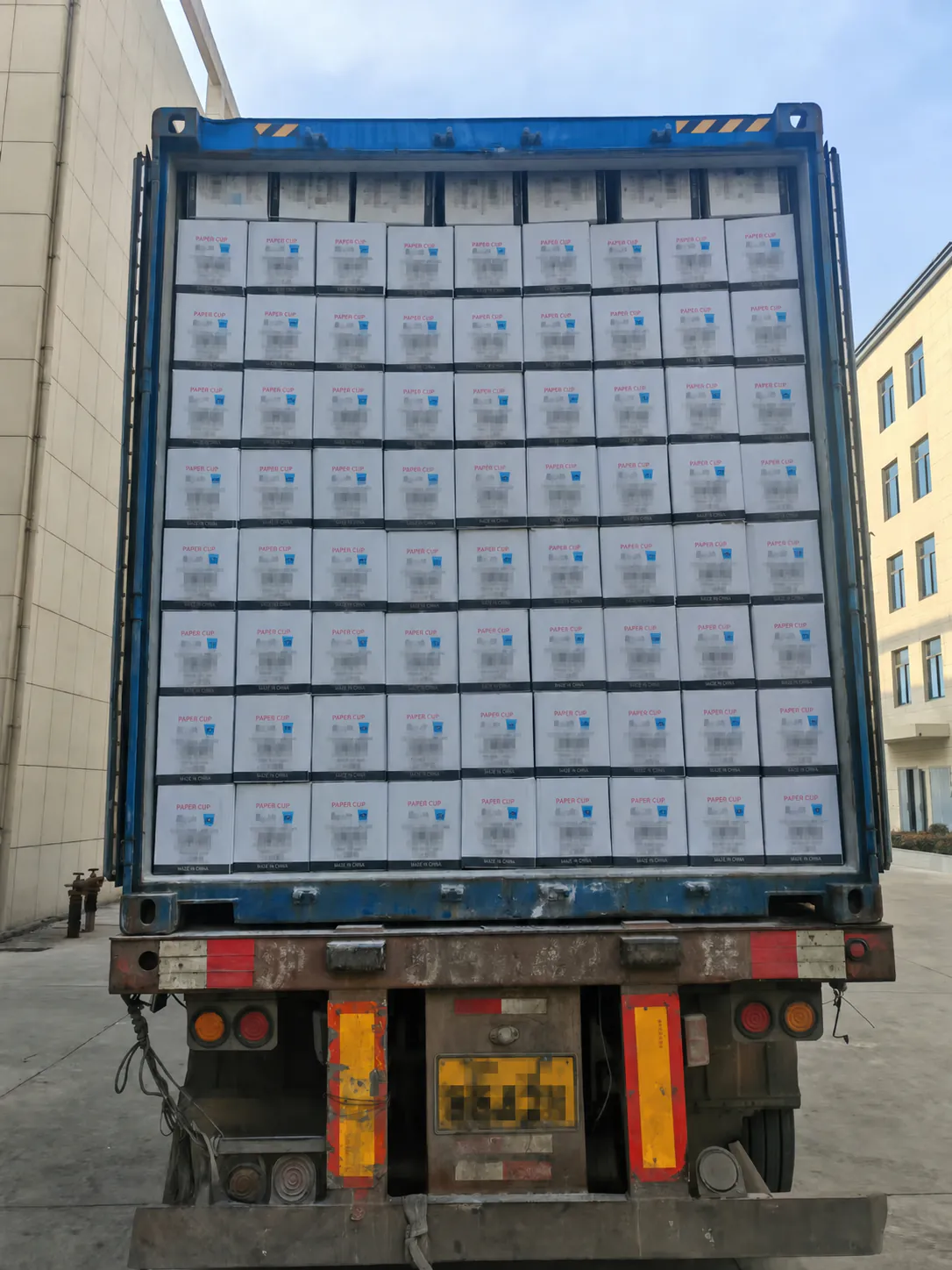 Paper cup cartons loaded in an export container with customer information redacted